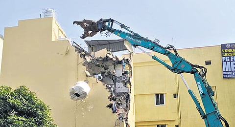 A water tank falls from the five-storey tilted building while being demolished by GHMC in Siddiqnagar, Gachibowli on Wednesday