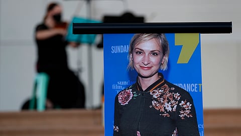 A musician plays a violin behind a photograph of cinematographer Halyna Hutchins during a vigil in her honor in Albuquerque, N.M.,Oct. 23, 2021.