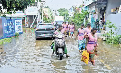 Motorists and pedestrians make their way through ankle-deep stagnant water in Thoothukudi on Thursday
