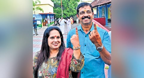 NDA candidate C Krishnakumar and wife Mini show their inked fingers at Ayyapuram LP School in Kalpathy