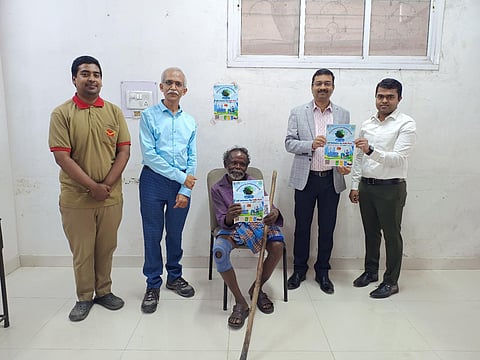 Periasamy Govindan with the poster which has QR code created for him. To his right is Chief Postmaster General, Karnataka Circle, Rajendra S Kumar (blue) and to his right is LK Dash, Postmaster General, Bengaluru HQ Region.