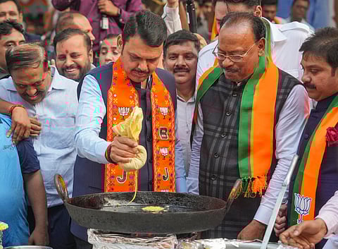 Maharashtra DCM Devendra Fadnavis prepares 'jalebi' at the BJP office as State BJP incharge Chandrashekhar Bawankule look on during celebrations after party's win in the Assembly elections, in Mumbai, Saturday, Nov. 23, 2024.
