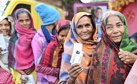 A voter shows her identification card as she waits to cast her vote.