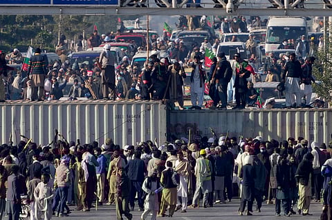 Supporters of imprisoned former premier Imran Khan's Pakistan Tehreek-e-Insaf party, gather to remove shipping containers to clear way for their rally demanding Khan's release, in Islamabad.