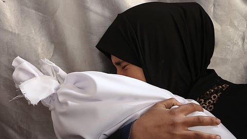 A Palestinian woman mourns as she holds the body of a relative, killed in an Israeli strike, at Al-Ahli Arab hospital, also known as the Baptist hospital, in Gaza City on November 27, 2024, amid the ongoing war in the Palestinian territory.