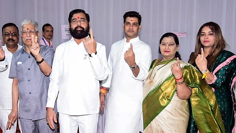 Eknath Shinde along with his wife Lata Shinde, son Shrikant Shinde and others show their ink-marked fingers after casting their vote for the state Assembly elections.