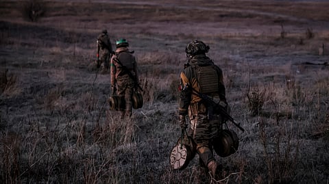 In this photo provided by Ukraine's 24th Mechanised Brigade press service, servicemen of the 24th Mechanised Brigade install anti-tank landmines and non explosive obstacles along the front line near Chasiv Yar town in Donetsk region.