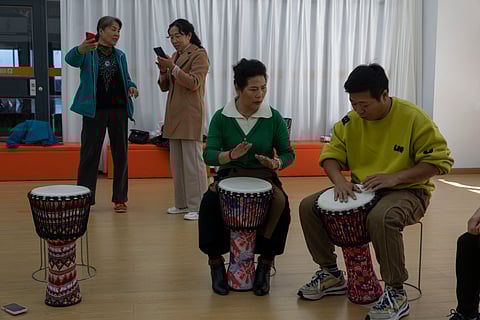 Cai Guixia, 60, second from right, learns African drumming from an instructor at the University for the Elderly in Beijing, Oct. 23, 2024.