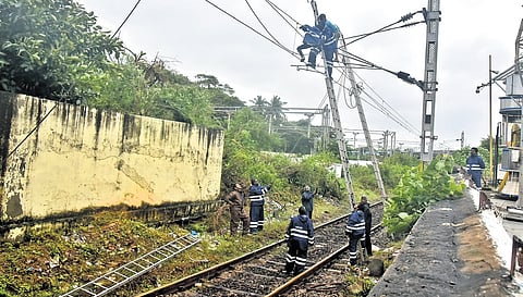 Railway workers repairing electrical lines that snapped in Chennai
