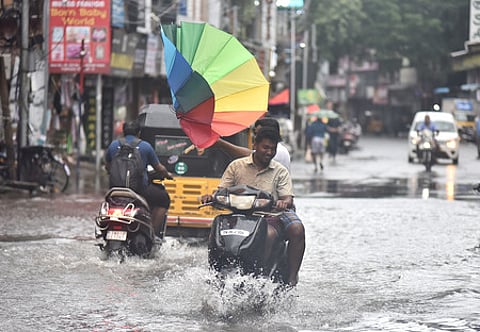 Youngsters struggling with umbrella during the Cyclone Fengal landfall process.
