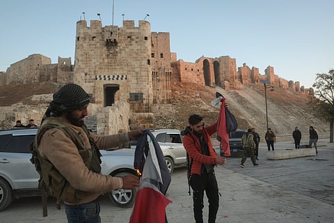 Syrian opposition fighters burn government Syrian flags for the cameras next to Aleppo's old city.