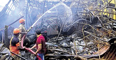 Fire and Rescue Services personnel dousing the fire at the scrap shop near the Ernakulam South railway overbridge on Sunday | A Sanesh