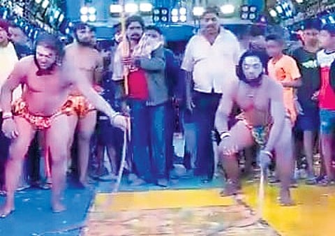 Screen grab of actors playing with snakes during the play.