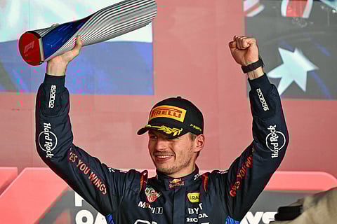 Race winner Red Bull Racing's Dutch driver Max Verstappen celebrates with the trophy on the podium after the Qatari Formula One Grand Prix at the Lusail International Circuit in Lusail, north of Doha, on December 1, 2024.
