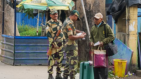 BSF personnel check passport of a Bangladeshi national returning to their country, at Petraploce border in North 24 Pargana district, West Bengal, Monday.