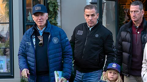 US President Joe Biden (L), accompanied by his son Hunter Biden (C), and his grandson Beau leave a book store as they walk in downtown Nantucket Mass., Friday, Nov. 29, 2024.