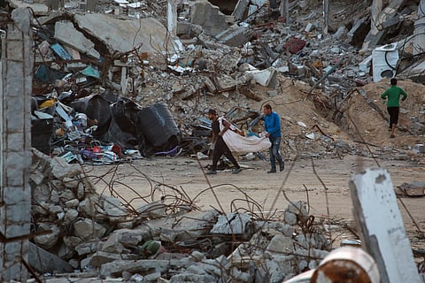 Palestinians collect firewood from the rubble in a devastated neighbourhood due to Israeli strikes in the southern Gaza Strip's city of Khan Yunis on December 2, 2024