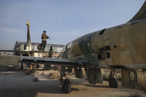 Syrian opposition fighters stand on the wings of an old aircraft at the Al-Nayrab military airport after they took control of the facility in the outskirts of Aleppo, Syria, Monday, Dec 2, 2024.