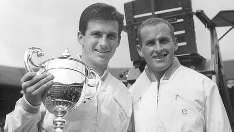 Ashley Cooper, left, holds the winner's trophy and poses with Neale Fraser after winning the men's singles championship in Wimbledon, July 4, 1958.