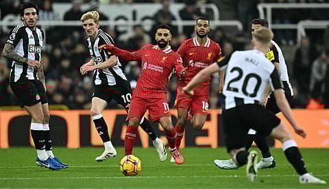 Liverpool's Mohamed Salah (C) vies with Newcastle United's English midfielder #20 Lewis Hall (R) during the EPL football match between Newcastle United and Liverpool on December 4, 2024.