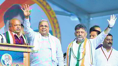 Chief Minister Siddramaiah and DyCM DK Shivakumar greet the gathering at the KPCC Janakalyana Swabhimana Samavesha in Hassan on Thursday.
