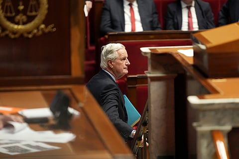 French Prime Minister Michel Barnier leaves after addressing the National Assembly prior to a vote on a no-confidence motion.