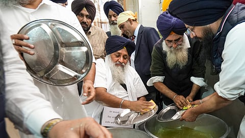 Shiromani Akali Dal leader Sukhbir Singh Badal washes dishes as he serves his Tankhah (religious punishment) at the Golden Temple, in Amritsar.