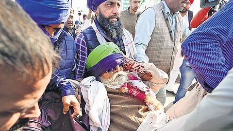 An injured farmer being carried after security personnel lobbed teargas to disperse protesters during their march to Delhi, at Shambhu border on Friday.