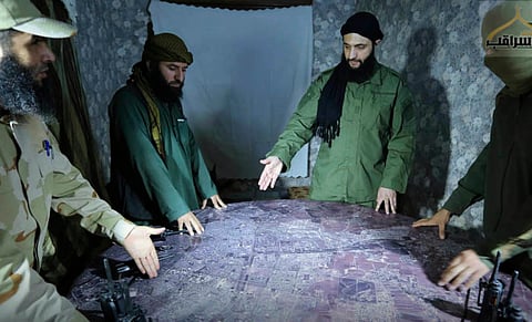 This undated photo released by a militant group in 2016, shows Abu Mohammed al-Golani, the leader of Syria's al-Qaida affiliate, second from right, discussing battlefield details with commanders in Aleppo, Syria.