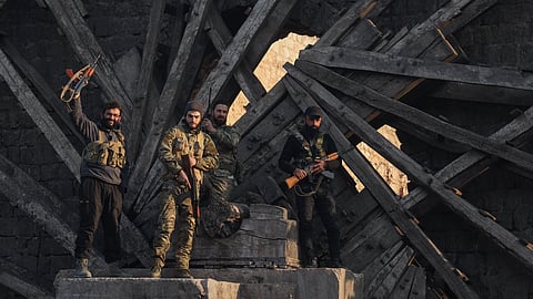 Insurgent fighters celebrate in the aftermath of the opposition's takeover of the city in downtown Hama, Syria