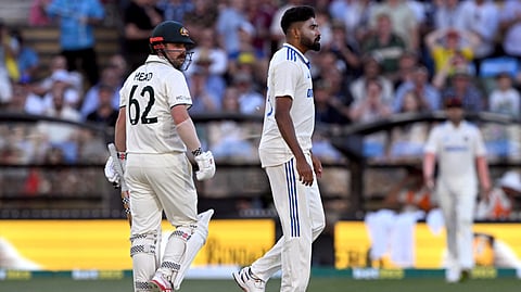 Australian batsman Travis Head (L) looks at Indian bowler Mohammed Siraj (R) on the second day of the second Test cricket match between Australia and India at the Adelaide Oval in Adelaide on December 7, 2024.