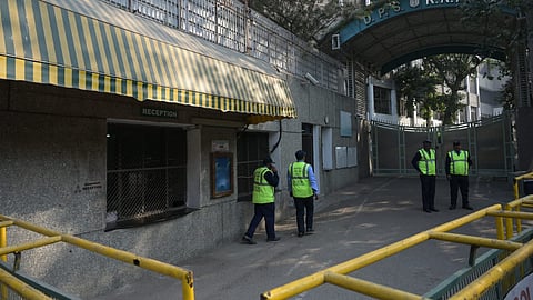Security personnel stand outside the DPS RKPuram after Receives Bomb threat in New Delhi on Monday.