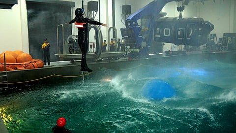 Navy personnel demonstrate rescue of pilots in turbulent water at the Water Survival Training Facility in Kochi