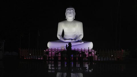 Carol Kruhen lifts up her pressed palms next to a statue of the Buddha after meditating at the New Jersey Buddhist Vihara and Meditation Center in Franklin Township, N.J. on Sunday, Nov 30, 2024.