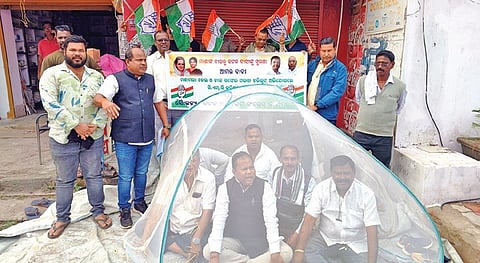 Congress activists on dharna in a mosquito net before Badambadi police station.