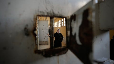 A woman examines the cells at the infamous Saydnaya military prison, just north of Damascus, Syria, on Monday, Dec. 9, 2024.