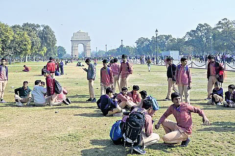 Schoolchildren playing on Central Vista lawns on a clear day at India Gate in New Delhi on Tuesday.