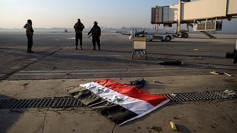 Syrian opposition fighters stand atop a seized Syrian Air Force fighter plane at the Hama military airport, Syria.