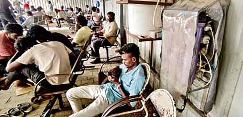 Men waiting on broken seats outside the Government Medical College Hospital in Tiruvallur