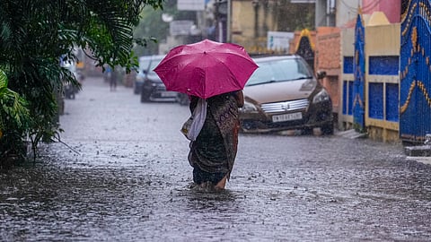 A pedestrian on a waterlogged street as widespread rains lashed parts of Tamil Nadu.
