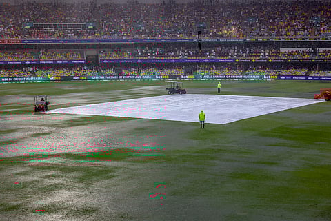 General view of covers on the pitch as it rain during play on day one of the third cricket test between India and Australia at the Gabba in Brisbane.