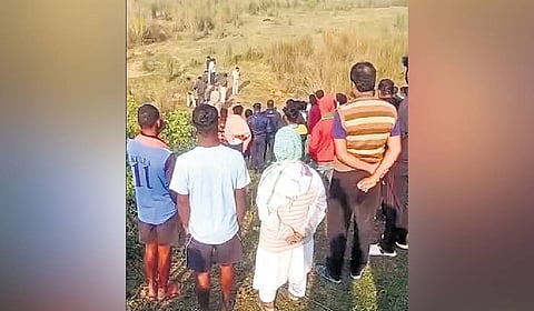Locals stand near the site where the woman's body was found.