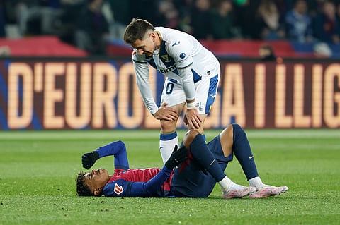 Leganes' Javi Hernandez, top, talks to Barcelona's Lamine Yamal as he lies on the pitch after a challenge during the Spanish La Liga soccer match between Barcelona and Leganes at the Lluis Companys Olympic Stadium in Barcelona.