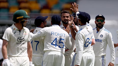 India’s Akash Deep (C) celebrates with team mates after dismissing Australia’s Nathan McSweeney (L) on day five of the third cricket Test match between Australia and India at The Gabba in Brisbane.