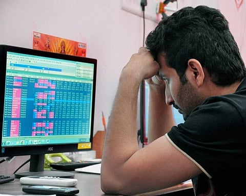 A broker reacts while watching the downfall of stocks as the BSE Sensex fell over 300 points in mid-morning trades