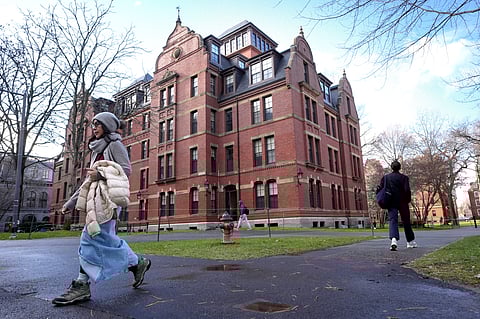 People walk between buildings, Tuesday, Dec. 17, 2024, on the campus of Harvard University in Cambridge, Mass.