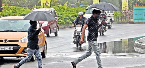 People walk amid rain in Bhubaneswar on Saturday.