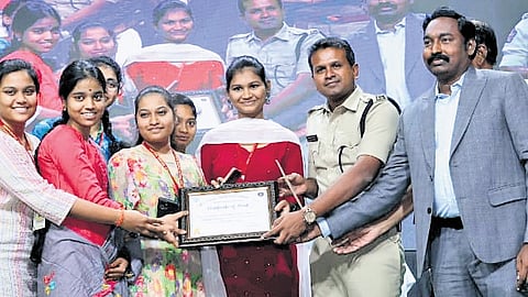 Guntur SP Sathish Kumar awarding prizes to winners of a short film competition focused on cybercrime awareness.