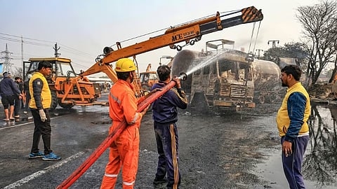 Firefighters douse the fire at the site of the accident after a truck loaded with a chemical collided with some other vehicles and caught fire on the Jaipur-Ajmer Highway.