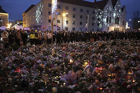 Flowers, candles and wide offerings of mourning in front of St. John's Church, close to the Christmas market where a car drove into a crowd on Friday evening in Magdeburg, Germany, Monday, December 23, 2024.